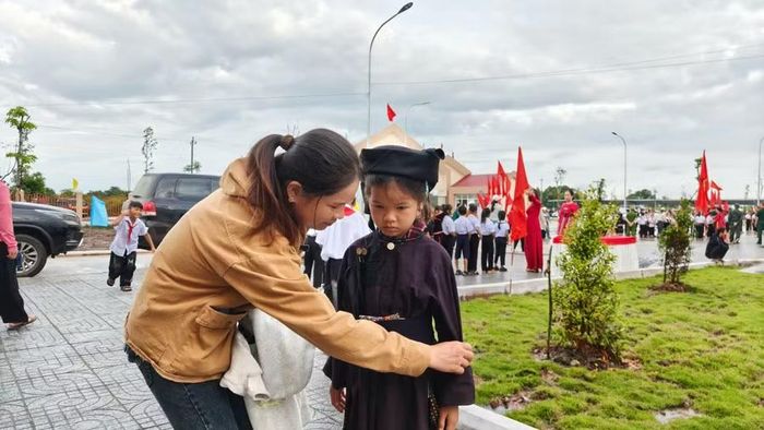 Chị Phạm Thị Tâm chỉnh sửa trang phục cho con.