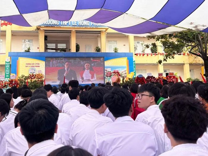 Các em học sinh Trường THPT Lê Hồng Phong ngồi ngay ngắn tại sân trường dự lễ, ngập tràn nét mặt phấn khởi trong tà áo và bộ đồng phục trắng tinh khôi, hòa chung không khí tưng bừng của ngày hội khai trường.