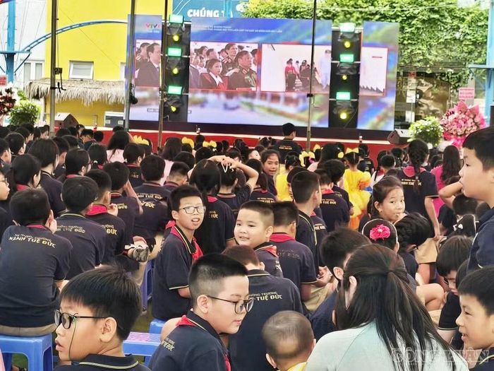Các em học sinh tiểu học Xanh Tuệ Đức tề tựu ngay ngắn tại sân trường, hướng ánh mắt về màn hình LED lớn để theo dõi chương trình truyền hình trực tiếp lễ khai giảng toàn quốc phát sóng trên VTV1.