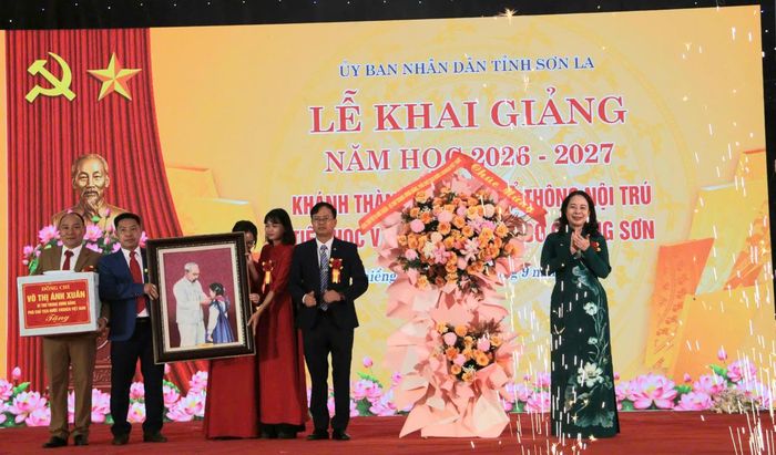 Bà Võ Thị Ánh Xuân, Bí thư Trung ương Đảng, Phó Chủ tịch nước tặng hoa và quà chúc mừng Trường Phổ thông nội trú TH và THCS Chiềng Sơn (Ảnh: PV).