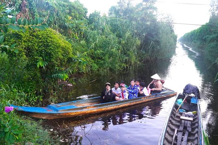 Nhiều em học sinh phải đi xuồng máy ra điểm chính dự lễ khai giảng năm học mới.