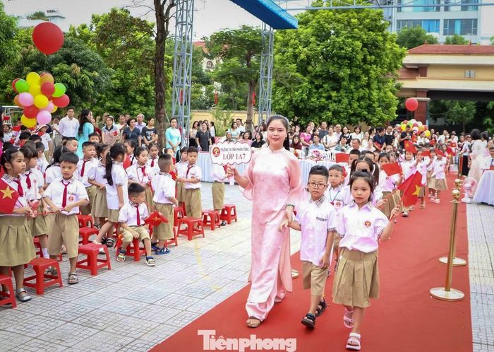 Các em học sinh lớp 1 hân hoan nối bước vào sân trường trong sự chào đón của thầy cô và học sinh toàn trường.