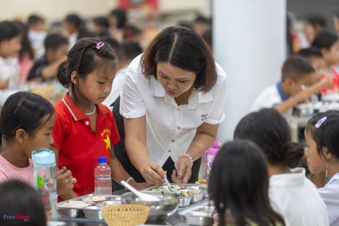 Cô Trang Thu Hường - Hiệu phó nhà trường có mặt tại nhà ăn kiểm tra công tác chuẩn bị cho học sinh và dỗ dành các em còn bé.