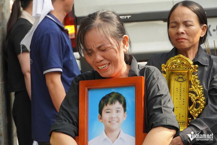 Chị Nga ôm di ảnh cháu oà khóc.