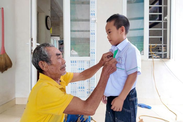 Từ sáng sớm, phụ huynh của học sinh đã mặc cho con em mình những bộ đồng phục mới để tới trường. Ảnh: T.B