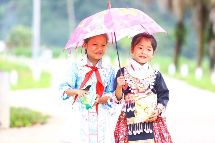 Các em học sinh vùng cao men theo con đường đến trường trong bộ trang phục mang đậm bản sắc văn hóa.