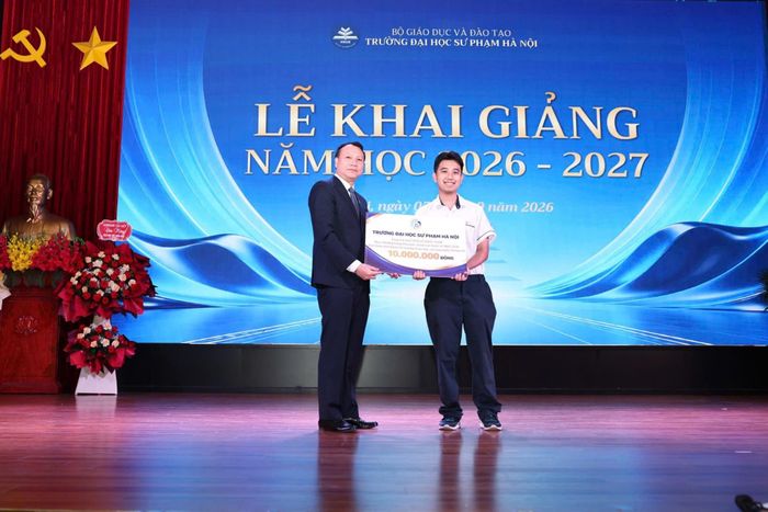 PGS.TS Nguyễn Đức Sơn, Hiệu trưởng Trường ĐH Sư phạm Hà Nội trao thưởng cho tân sinh viên Nguyễn Lê Nhật Nam - từng giành Huy chương Vàng Olympic Toán quốc tế năm 2026 - chọn theo học ngành Sư phạm Toán học của trường. 