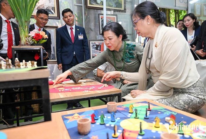 Hai phu nhân chơi trò chơi dân gian ô ăn quan của Việt Nam. Các viên chơi ô ăn quan được làm bằng vải vụn 