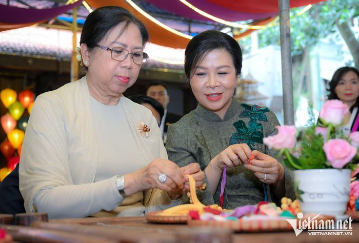 Phu nhân Ngô Phương Ly và phu nhân Kyu Kyu Hla trải nghiệm xâu vòng lụa với các cháu thiếu niên, nhi đồng của làng nghề