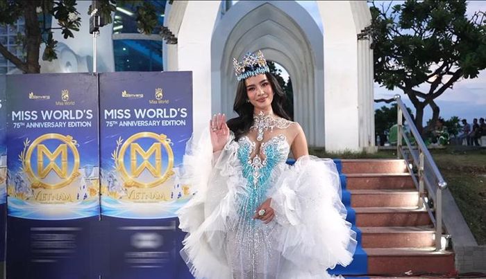Đương kim Hoa hậu Thế giới Opal Suchata xuất hiện rạng rỡ trong đầm trắng - xanh ngọc đính kết cầu kỳ, phần tay áo voan bồng bềnh tạo hiệu ứng bay bổng. Vương miện Miss World được cô đội cao, kết hợp trang điểm tông cam đào tươi tắn và nụ cười rạng ngời.