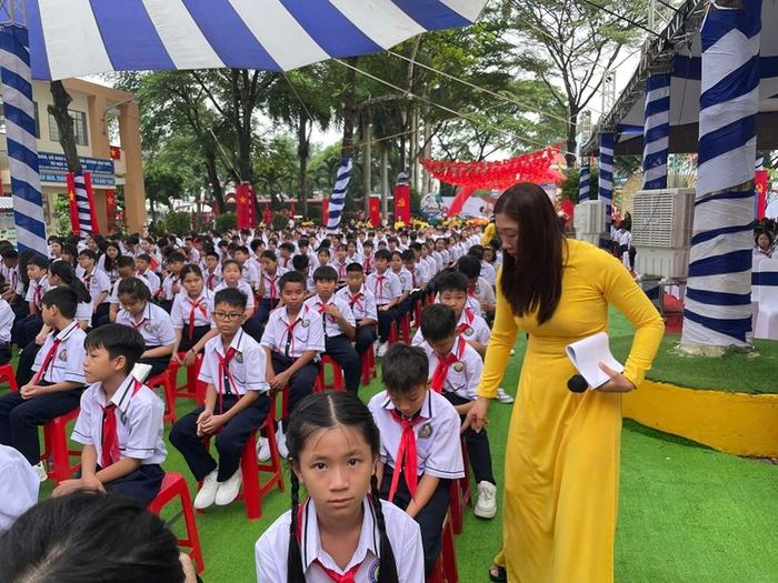  Giáo viên hướng dẫn các em học sinh ngồi xếp hàng trật tự.