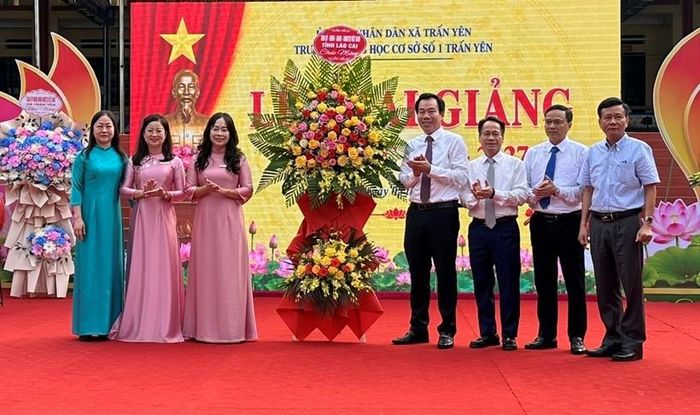 Đồng chí Dương Đức Huy, Trưởng Ban Tuyên giáo Tỉnh ủy; đồng chí Đỗ Đình Chữ, Viện trưởng VKSND tỉnh Lào Cai cùng thành viên đoàn công tác tặng hoa chúc mừng Trường THCS số 1 Trấn Yên.