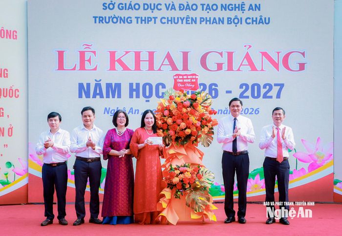 Phó Bí thư Thường trực Tỉnh ủy, Chủ tịch HĐND tỉnh Hoàng Nghĩa Hiếu và Phó Chủ tịch UBND tỉnh Thái Văn Thành tặng hoa chúc mừng của Tỉnh ủy, HĐND, UBND, Ủy ban MTTQ Việt Nam tỉnh Nghệ An đến Trường THPT chuyên Phan Bội Châu. Ảnh: Thành Duy