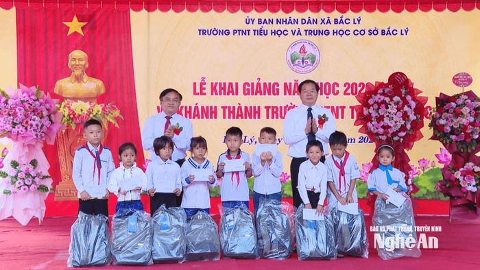 Đồng chí Ngọc Kim Nam - Ủy viên Ban Thường vụ, Trưởng Ban Tuyên giáo và Dân vận Tỉnh ủy cùng đồng chí Nguyễn Đức An - Ủy viên Ban Chấp hành Đảng bộ tỉnh - Phó Giám đốc Sở Xây dựng tặng quà cho học sinh có hoàn cảnh khó khăn. Ảnh: Sỹ Đức