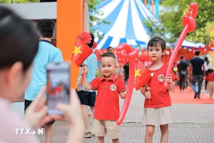 Phụ huynh chụp ảnh lưu niệm cho con trước khi bước vào lớp học tại Trường mầm non Kim Liên (Hà Nội). (Ảnh: Lê Đông/TTXVN)