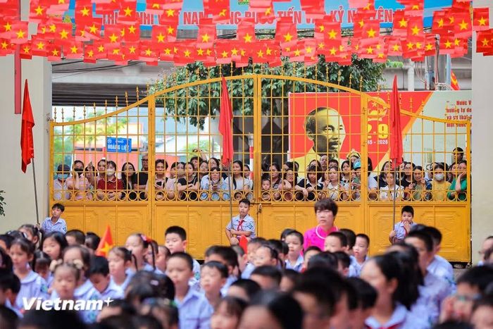 Hòa chung không khí ấy là sự dõi theo của các bậc phụ huynh phía cổng trường. (Ảnh: Hoài Nam/Vietnam+)