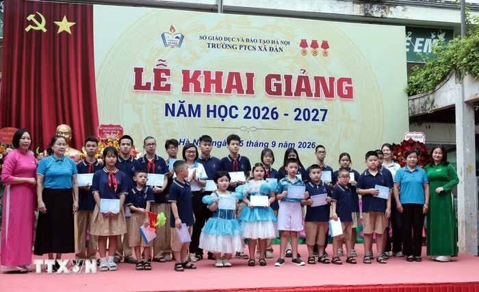 Tặng quà cho các em học sinh trường Phổ thông cơ sở Xã Đàn ngày khai giảng. (Ảnh: Trần Việt/TTXVN)