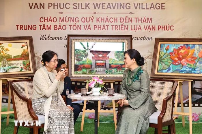 Phu nhân Ngô Phương Ly và Phu nhân Kyu Kyu Hla thưởng trà tại làng lụa Vạn Phúc. (Ảnh: Minh Đức/TTXVN)