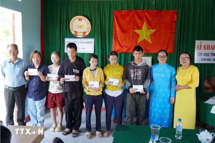 Tặng quà cho học sinh khuyết tật. (Ảnh: Lê Phước Ngọc/TTXVN)