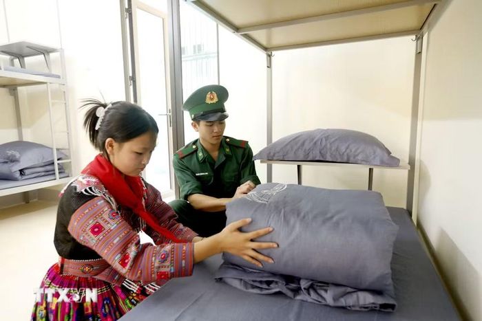 Chiến sỹ Đồn Biên phòng Chiềng Sơn (Ban Chỉ huy Bộ đội Biên phòng tỉnh Sơn La) hướng dẫn gấp chăn cho học sinh Trường phổ thông nội trú Tiểu học và Trung học cơ sở Chiềng Sơn. (Ảnh: Quang Quyết/TTXVN)