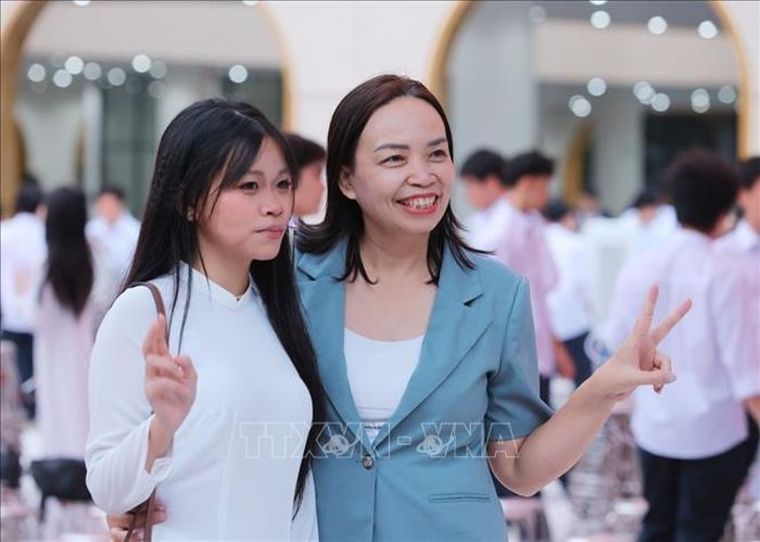 Phụ huynh và học sinh Trường THPT Việt Đức lưu lại kỷ niệm trong ngày đầu tiên của năm học mới 2026 - 2027. Ảnh: Hoàng Hiếu/TTXVN