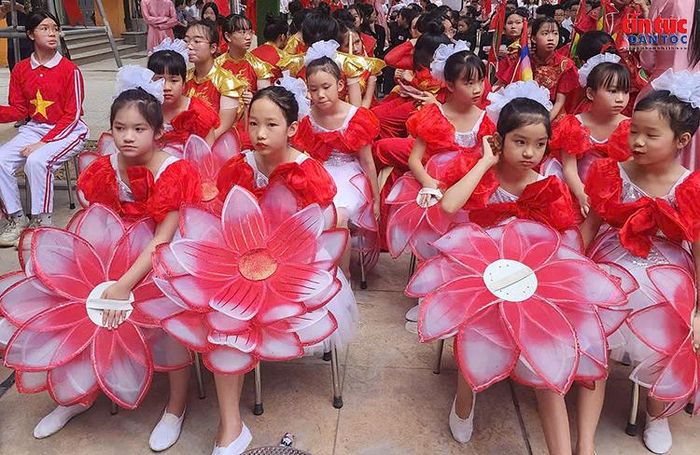 Từ 6 giờ 30 phút, sân trường đã đông kín học sinh, giáo viên và phụ huynh. Cờ hoa rực rỡ được trang hoàng, tạo không khí phấn khởi, náo nức trước thềm năm học mới.