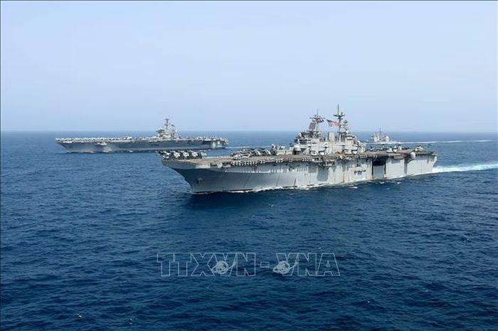 Tàu sân bay USS Abraham Lincoln (phía sau) của hải quân Mỹ di chuyển trên Biển Arab. Ảnh: AP/TTXVN