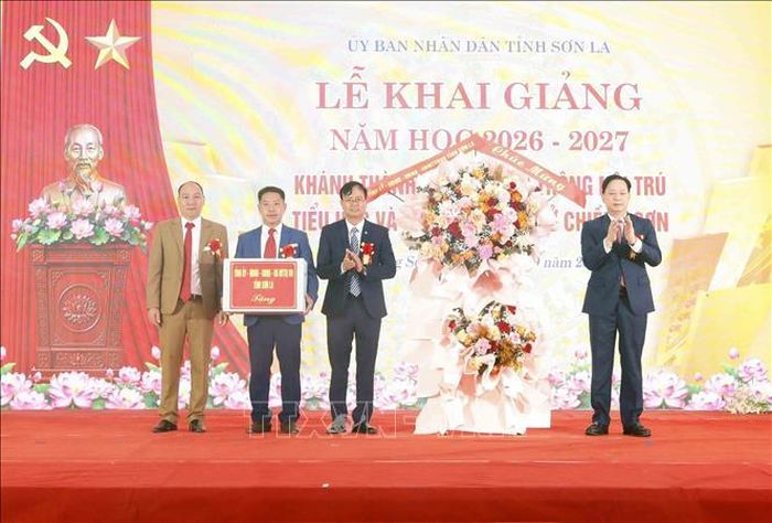 Bí thư Tỉnh ủy Sơn La Hoàng Văn Nghiệm tặng hoa, quà chúc mừng tập thể Trường Phổ thông nội trú TH và THCS Chiềng Sơn (Sơn La). Ảnh: Quang Quyết/TTXVN