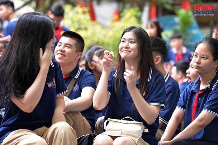 Học sinh vui vẻ giao tiếp với nhau bằng ngôn ngữ ký hiệu trong sân trường.