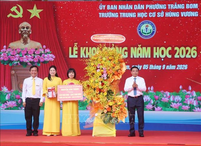 Đồng chí Nguyễn Văn Thắng tặng hoa chúc mừng lễ khai giảng và tặng sách giáo khoa, sách tham khảo cho Trường THCS Hùng Vương, phường Trảng Bom, thành phố Đồng Nai. Ảnh: Lê Xuân/TTXVN