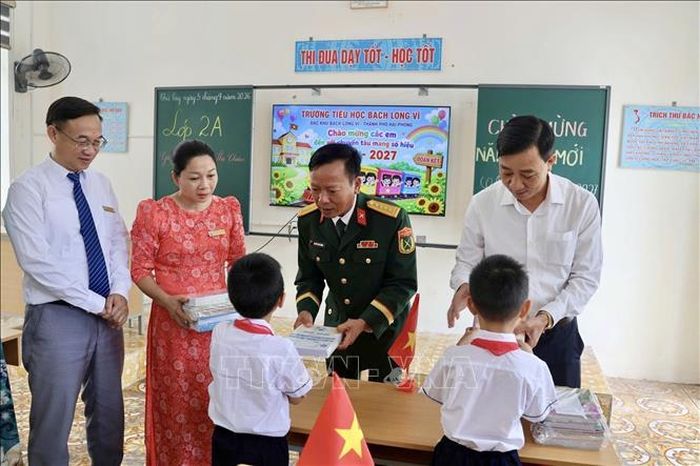 Đại diện lãnh đạo Đặc khu Bạch Long Vĩ, lực lượng vũ trang tặng sách vở cho các em học sinh trường Tiểu học Bạch Long Vĩ. Ảnh: TTXVN phát