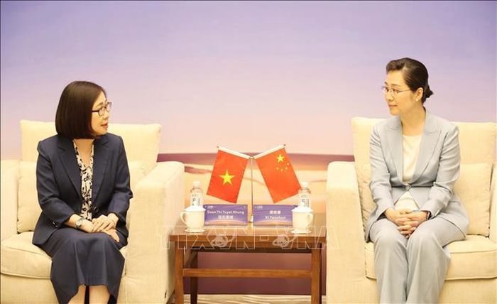 Phó Tổng Giám đốc TTXVN Đoàn Thị Tuyết Nhung (trái) gặp và làm việc với Phó Xã trưởng Tân Hoa xã Tập Diễm Xuân. Ảnh: Công Tuyên/PV TTXVN tại Trung Quốc