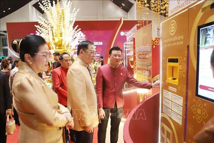 Thủ tướng Lào Sonexay Siphandone cùng Phu nhân tham quan mô hình tủ ATM Vàng Lào tại sự kiện. Ảnh: Xuân Tú/TTXVN