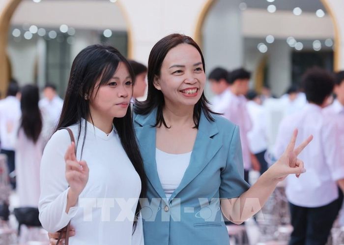 Phụ huynh và học sinh Trường THPT Việt Đức lưu lại kỷ niệm trong ngày đầu tiên của năm học mới 2026 - 2027. Ảnh: Hoàng Hiếu - TTXVN 
