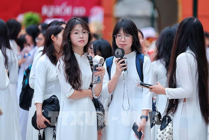 Nữ sinh Trường THPT Việt Đức trong tà áo dài trắng có mặt từ sớm, chuẩn bị tham dự Lễ khai giảng năm học 2026 – 2027. Ảnh: Phạm Tuấn Anh - TTXVN 