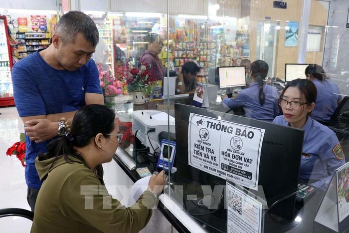 Anh Trần Quốc Hùng cùng người thân mua vé tại ga Sài Gòn sáng 5/9/2026 để về quê vợ ở Bình Định cũ (nay là tỉnh Gia Lai) dịp Tết Nguyên đán 2027. Ảnh: Tiến Lực - TTXVN