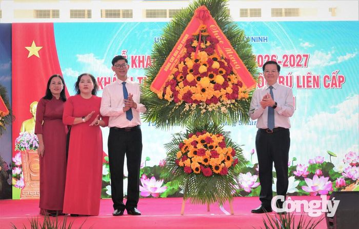 Nguyên Phó Thủ tướng Chính phủ Mai Văn Chính (bìa phải) tặng hoa chúc mừng khai giảng. Ảnh: Kiên Định.