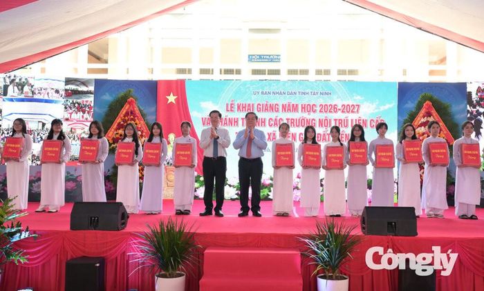 Đại tướng Nguyễn Trọng Nghĩa và nguyên Phó Thủ tướng Chính phủ Mai Văn Chính tặng quà động viên học sinh trong năm học mới. Ảnh: Kiên Định.