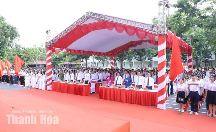 Các đồng chí lãnh đạo tỉnh và đại biểu cùng thầy, cô giáo, học sinh Trường THPT chuyên Lam Sơn thực hiện nghi lễ chào cờ.