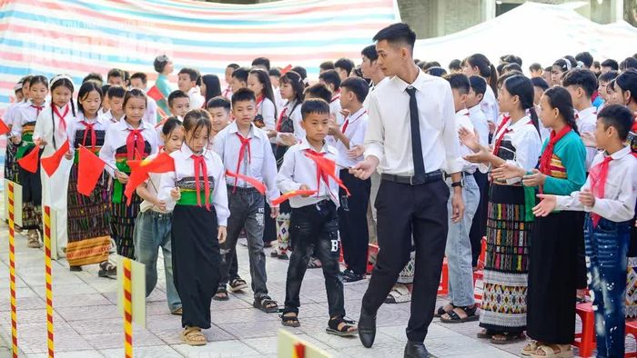 Những học sinh lớp 1, lớp 6 cầm trên tay lá cờ Tổ quốc, rạng rỡ bước vào cấp học mới.