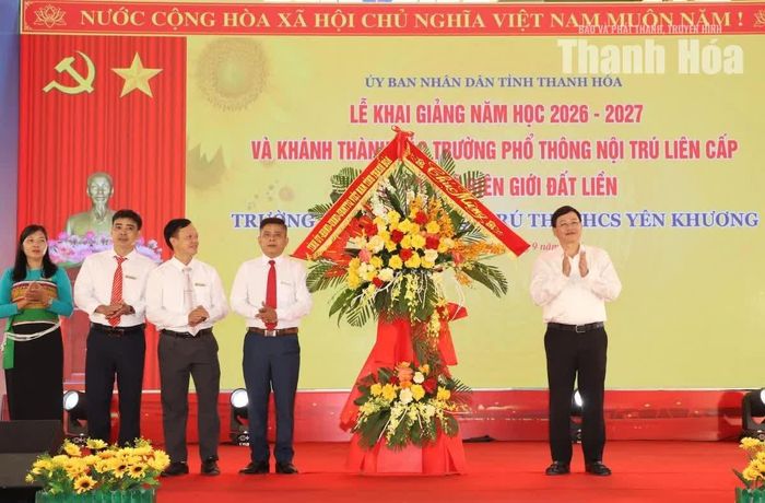 Phó Chủ tịch Thường trực UBND tỉnh Mai Xuân Liêm trao lẵng hoa chúc mừng của Tỉnh ủy, HĐND, UBND, Ủy ban MTTQ tỉnh cho nhà trường.