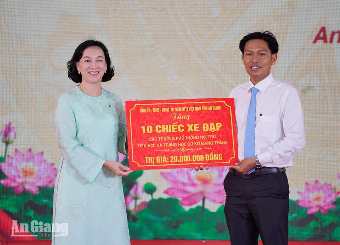 Phó Chủ tịch UBND tỉnh Nguyễn Thị Minh Thúy trao bảng tượng trưng 10 chiếc xe đạp cho Trường Phổ thông nội trú Tiểu học và THCS Giang Thành.