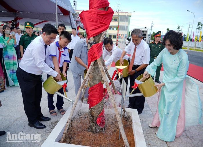 Các đại biểu tham gia trồng cây lưu niệm trong khuôn viên nhà trường.