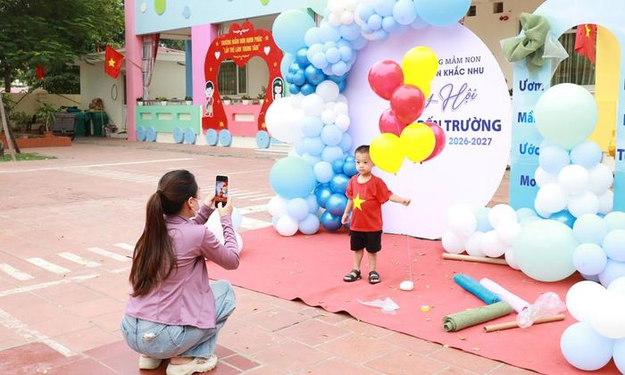  Tranh thủ chụp ảnh kỷ niệm cho con trước giờ khai giảng tại Trường Mầm non Nguyễn Khắc Nhu (phường Tiền Phong). 