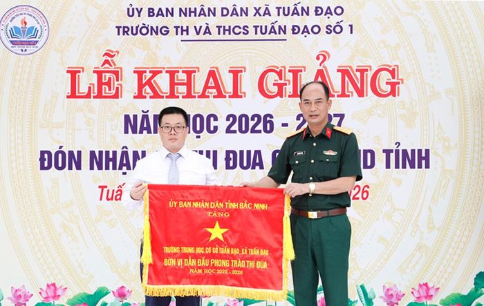  Đại tá Văn Khắc Thành trao tặng Cờ thi đua của UBND tỉnh cho Trường Tiểu học và THCS Tuấn Đạo số 1. 