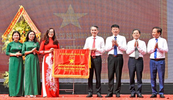  Đồng chí Vũ Minh Hiếu và các đại biểu trao tặng Cờ thi đua của UBND tỉnh cho tập thể nhà trường. 