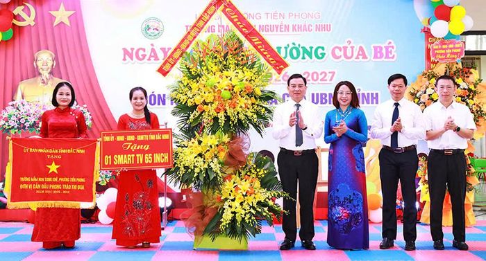  Đồng chí Vũ Trí Hải và các đại biểu tặng hoa, quà cho tập thể nhà trường. 