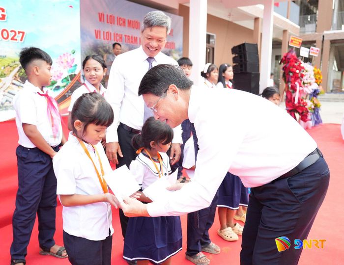 Phó Bí thư Thành ủy Ngô Xuân Thắng tặng quà cho học sinh tại lễ khai giảng. Ảnh: TRUNG LÊ