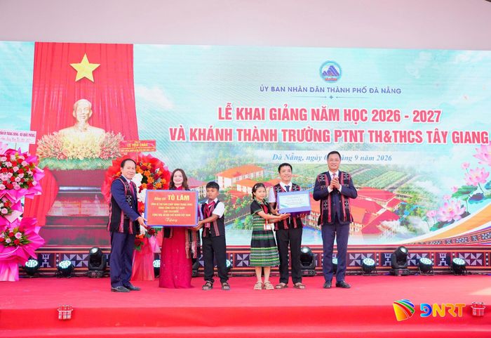 Phó Thủ tướng Chính phủ Lê Tiến Châu (ngoài cùng bên trái) và Bí thư Thành ủy Lê Ngọc Quang (ngoài cùng bên phải) thừa ủy quyền của Tổng Bí thư, Chủ tịch nước Tô Lâm và Phu nhân tặng quà cho thầy và trò Trường Phổ thông nội trú Tiểu học và THCS Tây Giang. Ảnh: T.CÔNG