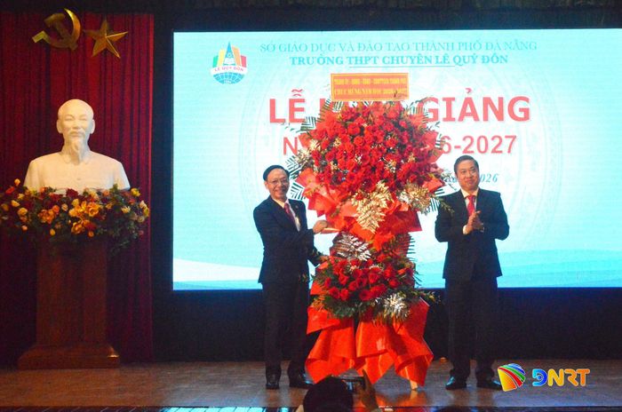 Phó Chủ tịch UBND thành phố Phan Thái Bình (bên phải) tặng hoa chúc mừng nhà trường. Ảnh: VĨNH LỘC